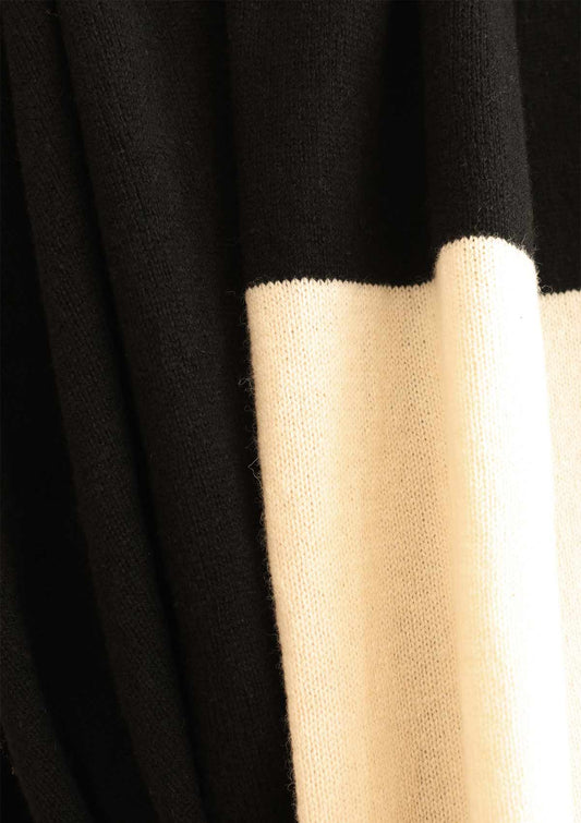 Detail of fine knit black cashmere blend scarf with a cream white stripe