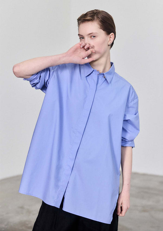 Model wearing Leophil relaxed Women's light blue cotton shirt with concealed shell buttons