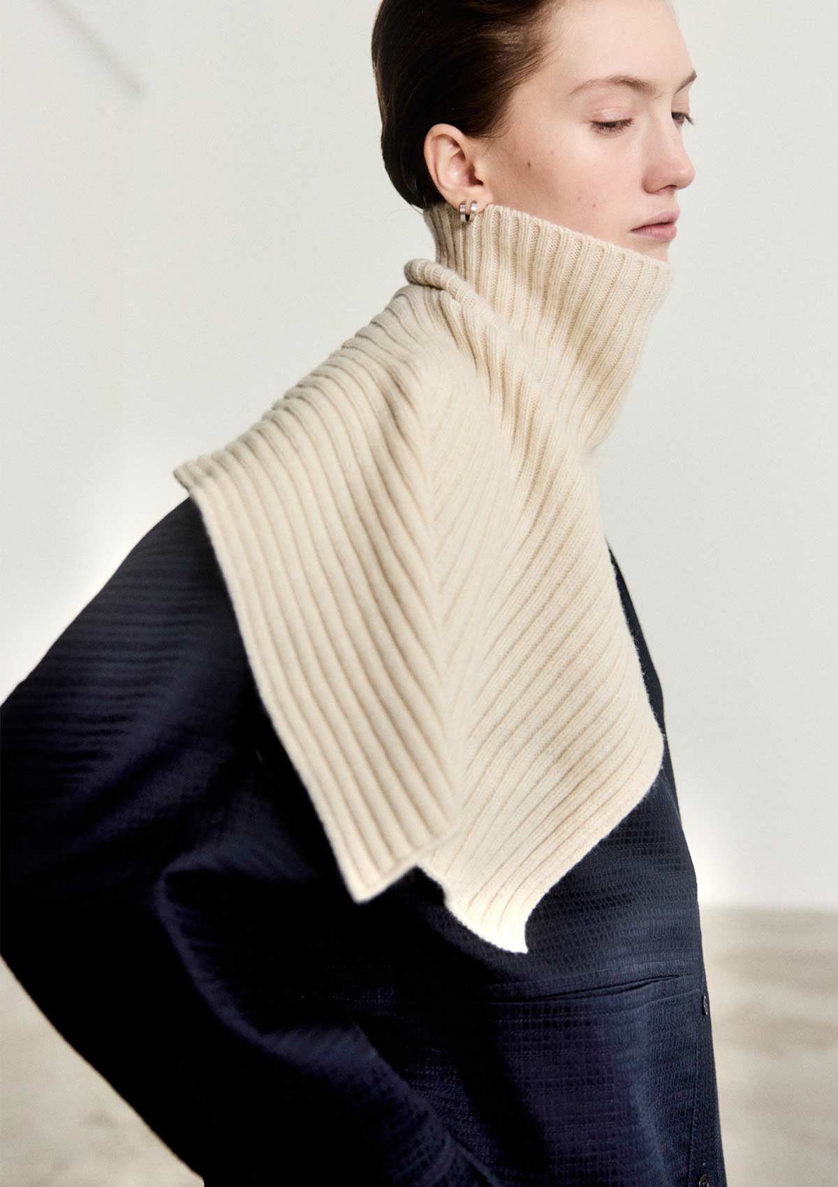 Model wearing the Leophil rib knit cape neck scarf in ivory cashmere wool