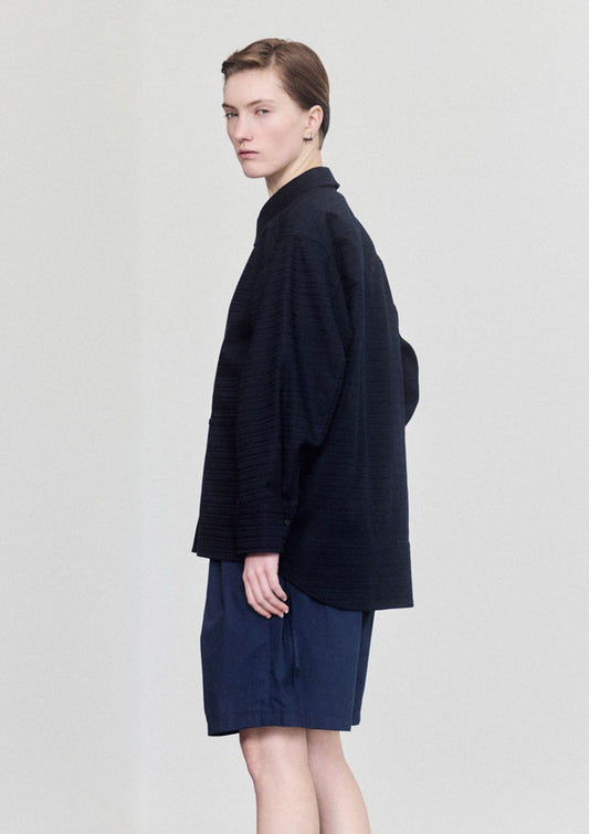 Model wearing navy textured cotton overshirt by Leophil