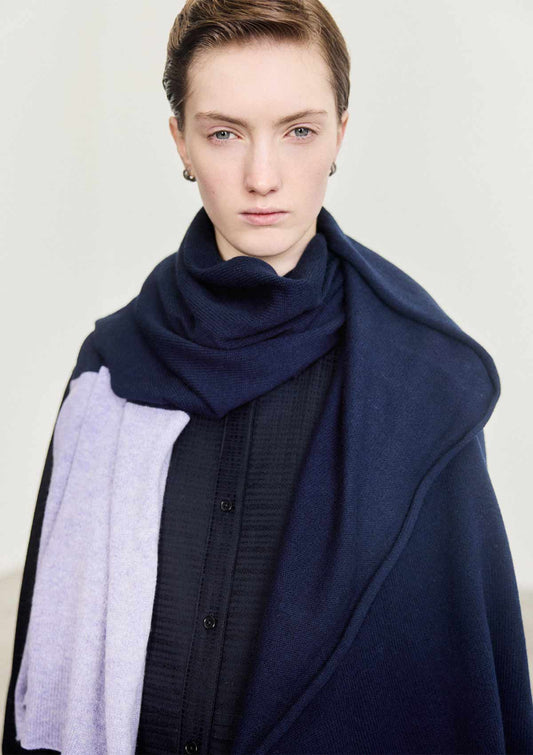 Model wearing the Leophil Ada cashmere knit scarf in navy with a lilac stripe
