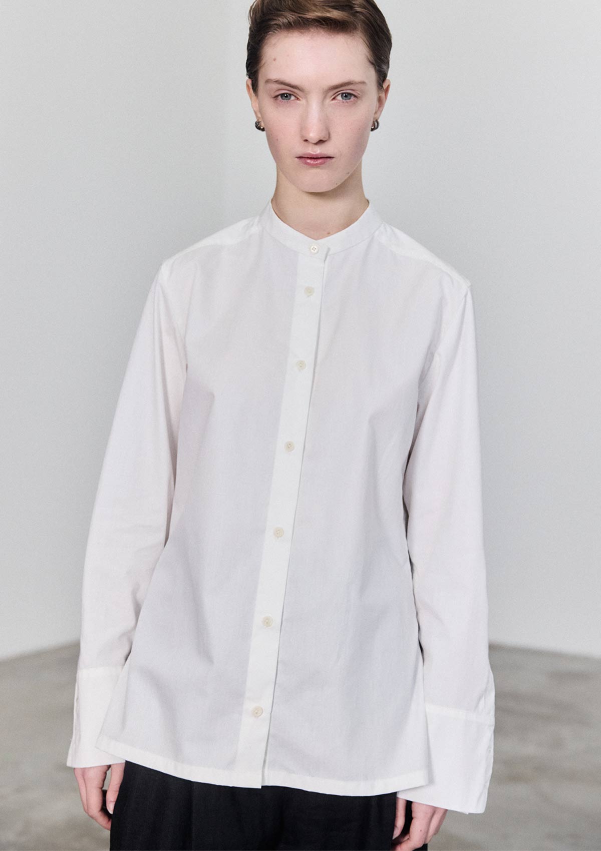 Model wearing slim white cotton women's shirt by Leophil